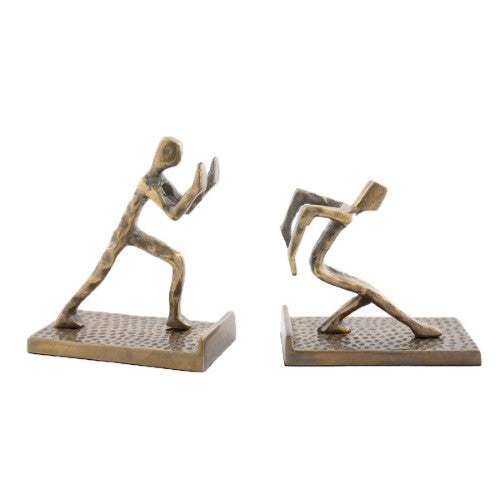 Aluminium bookends featuring dynamic figures pushing against books, perfect for stylish decor and organization.