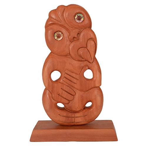 Handcrafted wooden tiki statue on stand, symbolizing ancestry and good fortune, ideal for unique home decor.