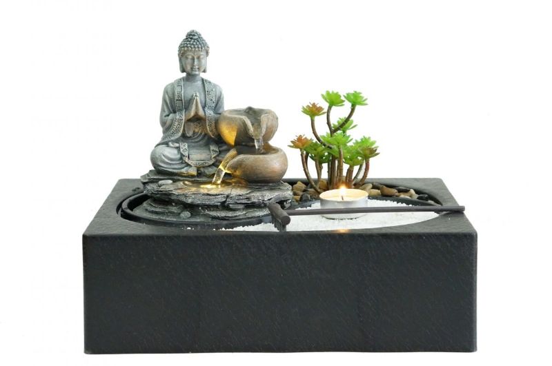 Indoor water fountain with a meditating Buddha, warm-white LED light, promoting tranquility and mindfulness in any space.