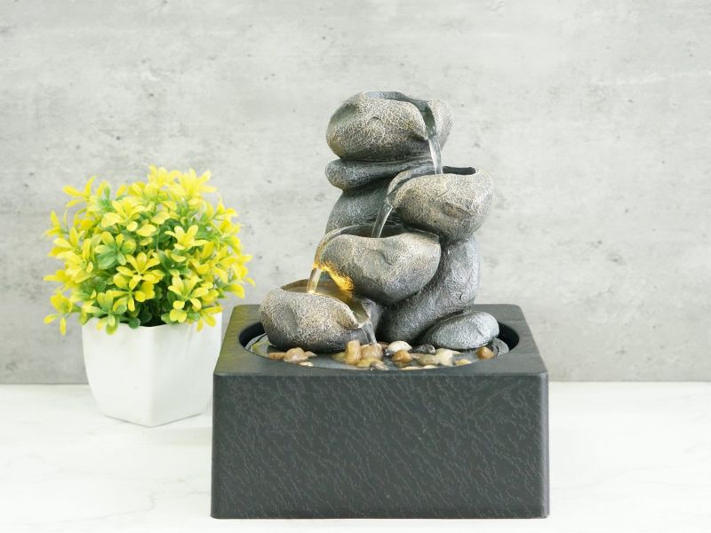 Elegant 25cm rock pool water feature with warm white LED lights, perfect for enhancing outdoor tranquility and ambiance.