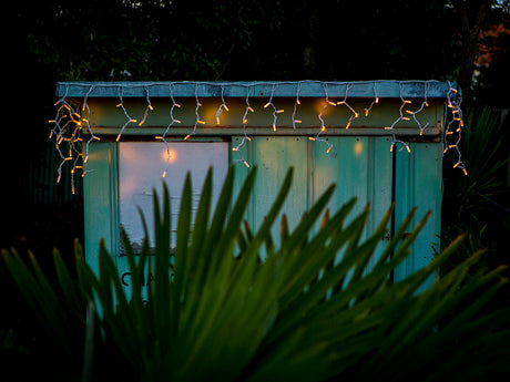 Warm white icicle fairy lights on a durable white cable, 3m long, perfect for indoor/outdoor festive decor.