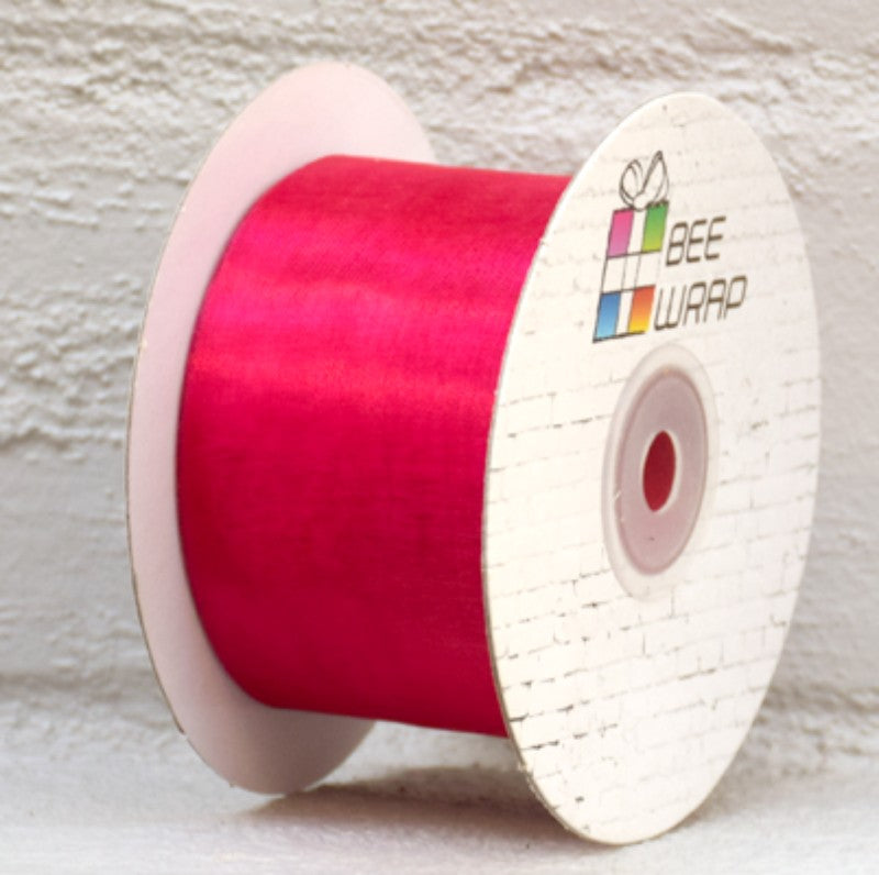 Hot pink organza ribbon, 50mm wide and 50m long, ideal for elegant gift wrapping and crafting projects.