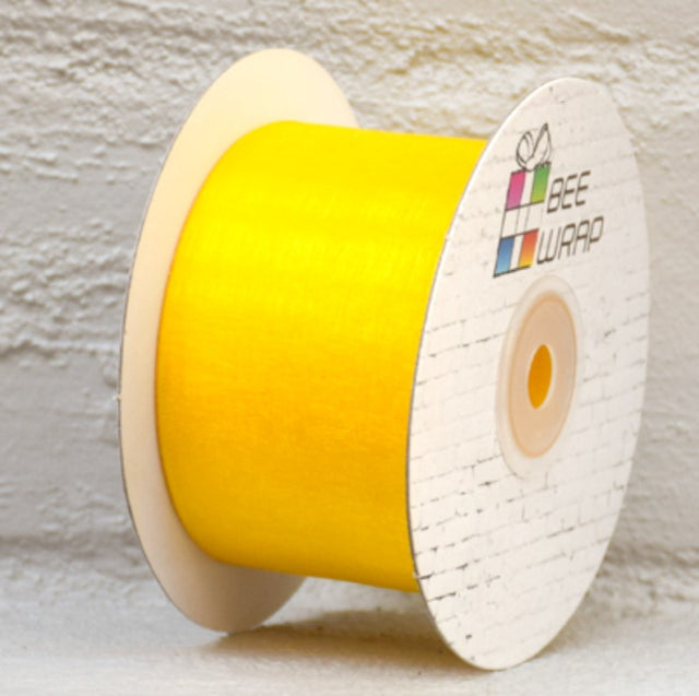 Vibrant yellow organza ribbon, 50mm wide and 50m long, perfect for gift wrapping and crafting elegant decorations.