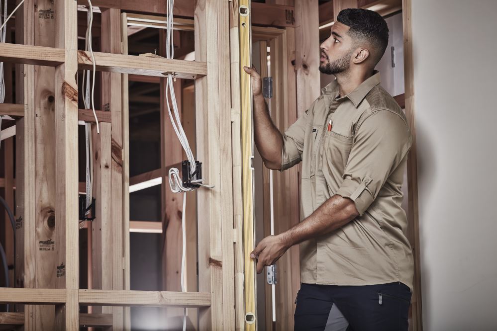 Men's khaki long sleeve stretch shirt from Syzmik, featuring roll-up sleeves and mobility-enhancing pleating for comfort.