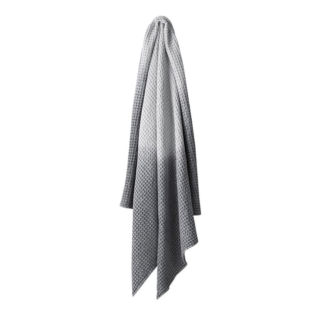 Hand dip dyed cotton throw, 140 x 200 cm, in smoke color with a waffle texture by Aura.