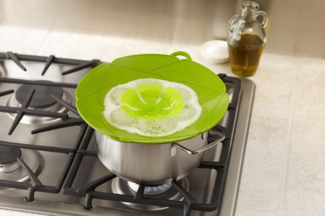 Large green spill stop lid, 29cm diameter, prevents boil-overs and splatters; heat-resistant silicone for easy kitchen use.