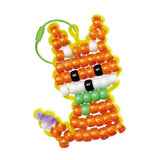 Colorful DIY kit to create a fox charm with glitter, UV, and color-changing beads for kids aged 6 and up.