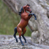 Majestic bay Arabian stallion figurine rearing on hind legs, hand-painted with vibrant details and lifelike expression.