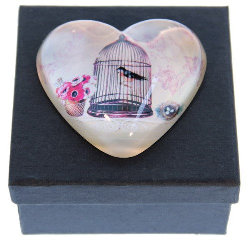 Elegant glass paperweight in heart shape within a birdcage, symbolizing love and freedom, perfect for decor and gifts.