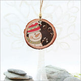 Wood slice ornament featuring a joyful snowman design, perfect for adding rustic charm to your Christmas tree.