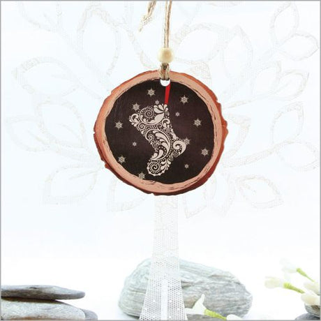 Wood slice ornament featuring intricate laser-cut filigree stocking design, perfect for festive decor or thoughtful gifts.