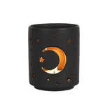 Small black ceramic tealight holder with moon and star cut-outs, creating a mystical ambiance for any space.