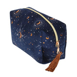 Blue velvet makeup bag with gold crescent moon accents and a tassel zipper, perfect for organizing beauty essentials.