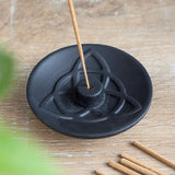 Black terracotta incense plate with triquetra design, ideal for enhancing spiritual spaces and burning incense safely.