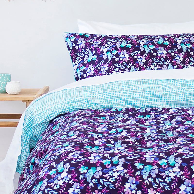 Queen duvet cover featuring a hand-painted floral design in purple, blue, and aqua green on luxurious cotton sateen fabric.