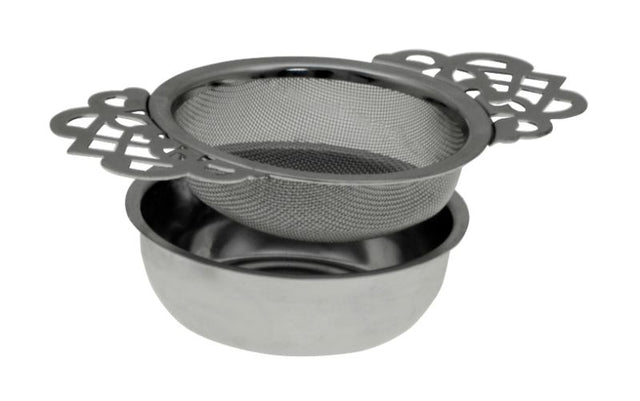Elegant stainless steel tea strainer with lace handles and drip tray, perfect for brewing loose leaf teas in style.