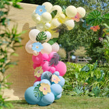 Colorful Tiki Tropics balloon arch featuring 70 balloons, tropical flowers, and foliage for festive decorations.