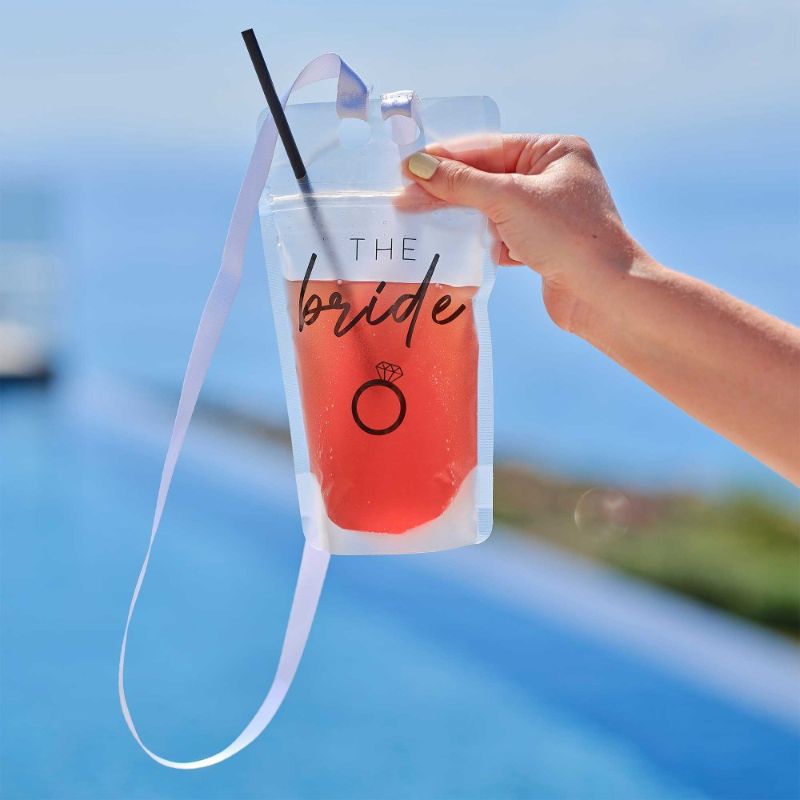 Bright pink hen party drink pouch for brides, featuring a straw and lanyard, perfect for celebrations and photo ops.