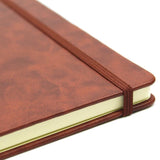 A sophisticated tan A4 executive notebook with 160 lined ivory pages, inside pocket, and elastic strap for secure storage.