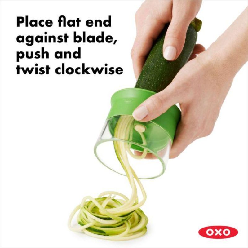 Hand-held spiralizer turning vegetables into spaghetti-like strands, featuring a non-slip grip and safety food holder for easy use.