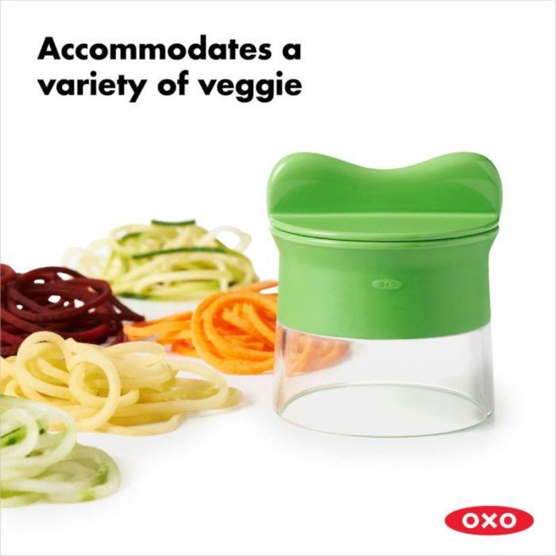 Hand-held spiralizer turning vegetables into spaghetti-like strands with non-slip grip and safety food holder for easy use.