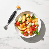 Stylish OXO melon baller with dual stainless steel scoops and ergonomic handle for perfect fruit and veggie portions.