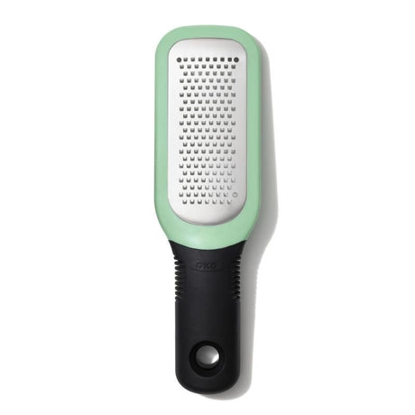 Hand-held grater with etched stainless steel teeth for easy garlic and ginger paste, featuring a soft handle and snap-on cover.