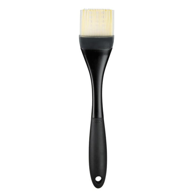 Silicone basting brush with heat resistance, tapered bristles, and an angled head for mess-free marinating and easy cleanup.