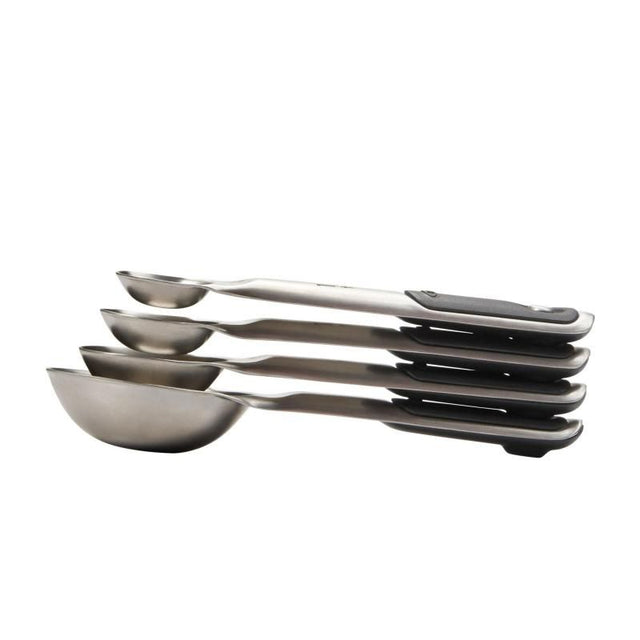 Set of four stainless steel measuring spoons with magnetic handles, featuring etched markings and non-slip grips for precise cooking.