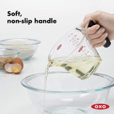 Angled measuring cup with non-slip handle, featuring clear markings for precise cooking and baking; dishwasher safe.