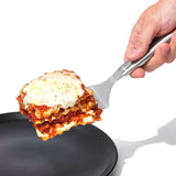 Stainless steel OXO Lasagna Turner with flexible angled head, ideal for serving lasagna, quiche, and more, featuring a comfortable grip.