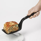 Broad nylon turner with angled neck for lifting lasagna, featuring heat-resistant design and stylish metal accents.