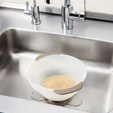 OXO Rice & Grain Washing Colander, designed for effortless washing of small grains with unique holes and a pour spout for easy draining.