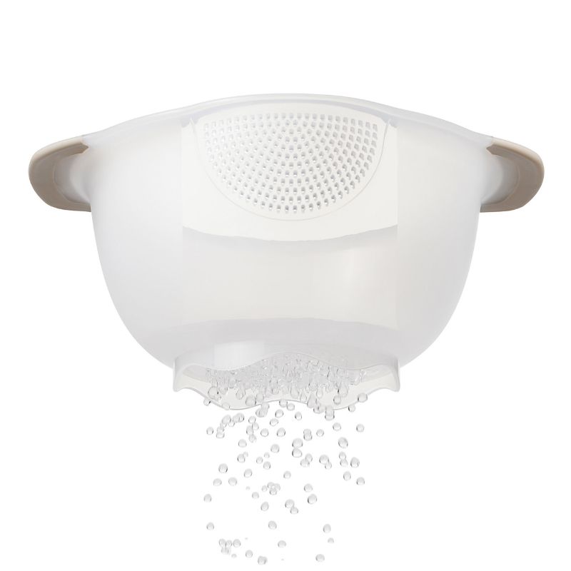 OXO Rice & Grain Washing Colander with unique drainage holes and non-slip handles for efficient rinsing of small grains.