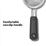 Compact OXO Good Grips Mini Strainer with fine mesh, double-rod stainless steel, and non-slip grip for easy straining.