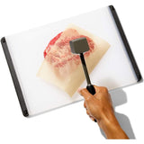 Two-sided meat tenderizer with pyramid-shaped teeth for tenderizing and a smooth side for even flattening, featuring an ergonomic design.