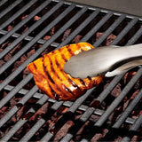 Set of stainless steel grilling tongs and turner with ergonomic grips, ideal for flipping meats and vegetables safely.