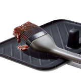 OXO Good Grips Grilling Basting Brush with silicone bristles and long handle, perfect for mess-free basting and flavor delivery.