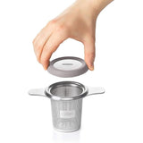 Stainless steel tea infuser basket with etched holes, large capacity, and dual-function lid for optimal brewing of loose leaf tea.