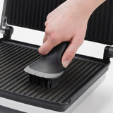 OXO Electric Grill & Panini Press Brush with soft bristles and silicone wiper for easy cleaning of non-stick surfaces.