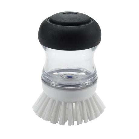 Ergonomic soap dispensing palm brush with durable bristles for easy cleaning of non-stick cookware and pots.