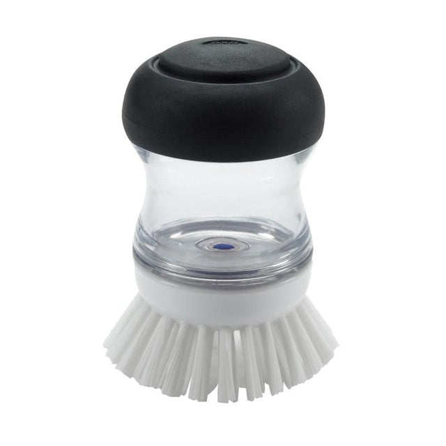 Ergonomic soap dispensing palm brush with durable bristles for easy cleaning of non-stick cookware and pots.