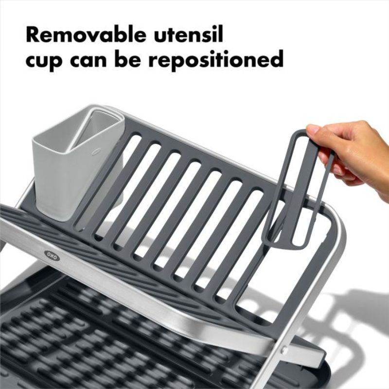 OXO Good Grips Aluminum Drying Rack with fold-flat design, rustproof frame, drainboard, and removable utensil cup for efficient drying.