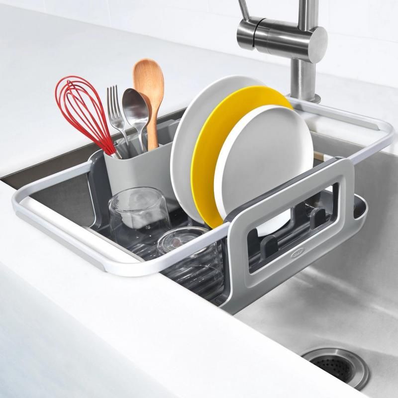 Sleek aluminum dish rack with extendable arms, plate holders, and utensil cup for efficient drying over the sink.