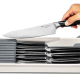 OXO Compact Knife Drawer Organiser with slots for 5 small and 4 large knives, featuring non-slip feet and a removable tray.