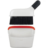 Compact dustpan and brush set with a slim design, covered bristles, and rubber lip for efficient cleaning in tight spaces.