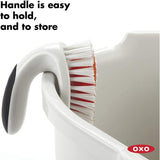 OXO Good Grips ALL-PURPOSE Scrub Brush with ergonomic non-slip handle, blending stiff and gentle bristles for effective cleaning.