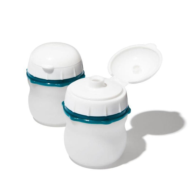 Two OXO Good Grips silicone squeeze bottles with wide mouths, leakproof lids, ideal for dressings and travel toiletries.