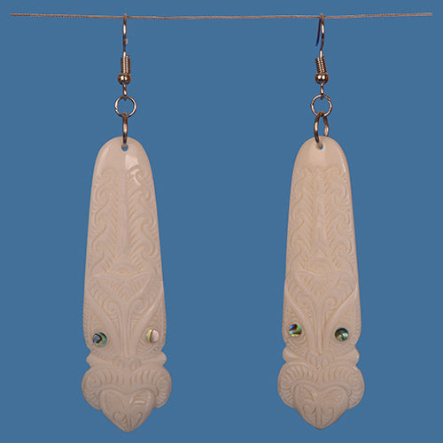 Bone Toki Earrings featuring a carved Tiki face with paua shell accents, blending Maori artistry and modern elegance.