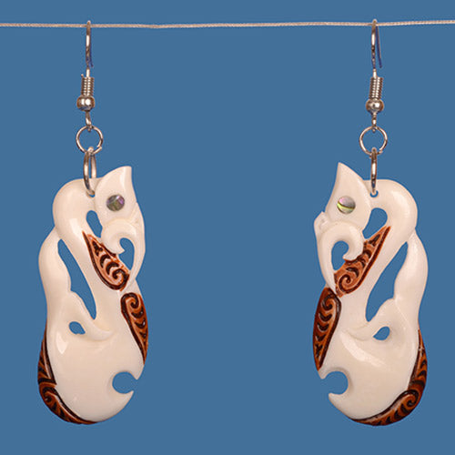 Handcrafted Manaia Bone Earrings with paua shell inlays, featuring unique staining and measuring 69mm total drop length.